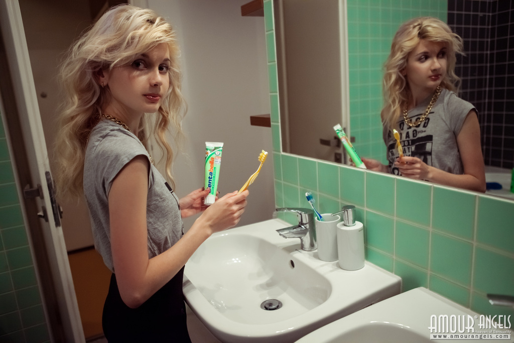 美丽的Angelik张开双腿跪下展示她的小屁股和少女的乳房