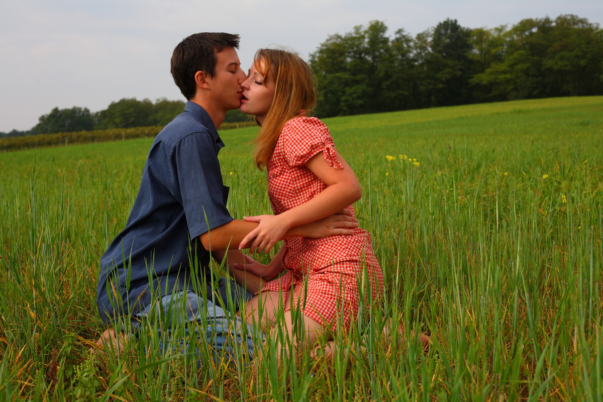 Young Couple Have Sexual Intercourse In A Burgeoning Field Of Hay